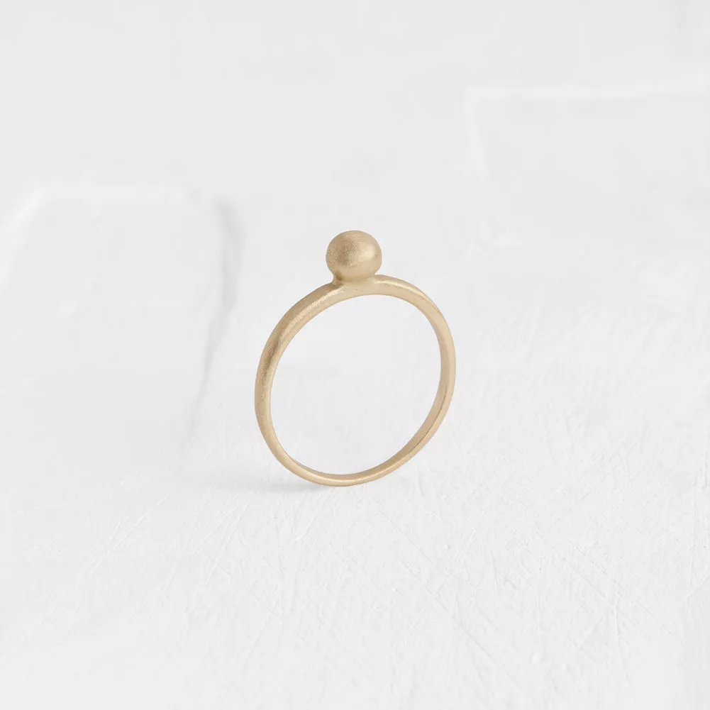 The perfect formalistic ring: a chunk of gold shaped into a flawless ball, placed on a simple hoop.