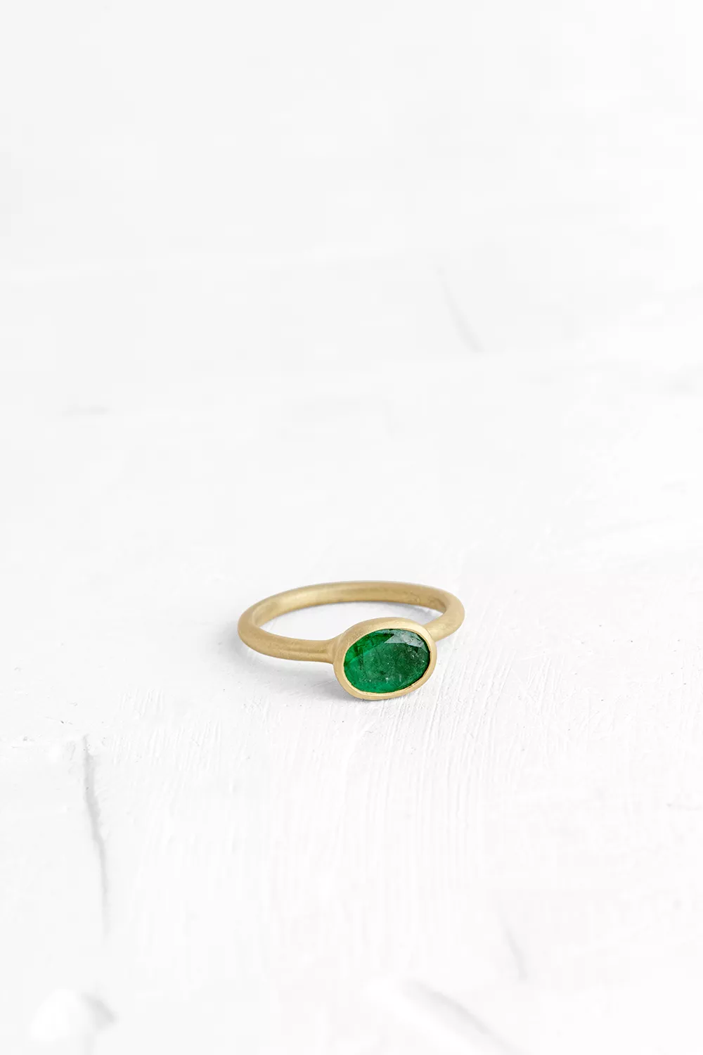A timeless piece which always steals the show: a gold ring set with a deep green Emerald gem stone.