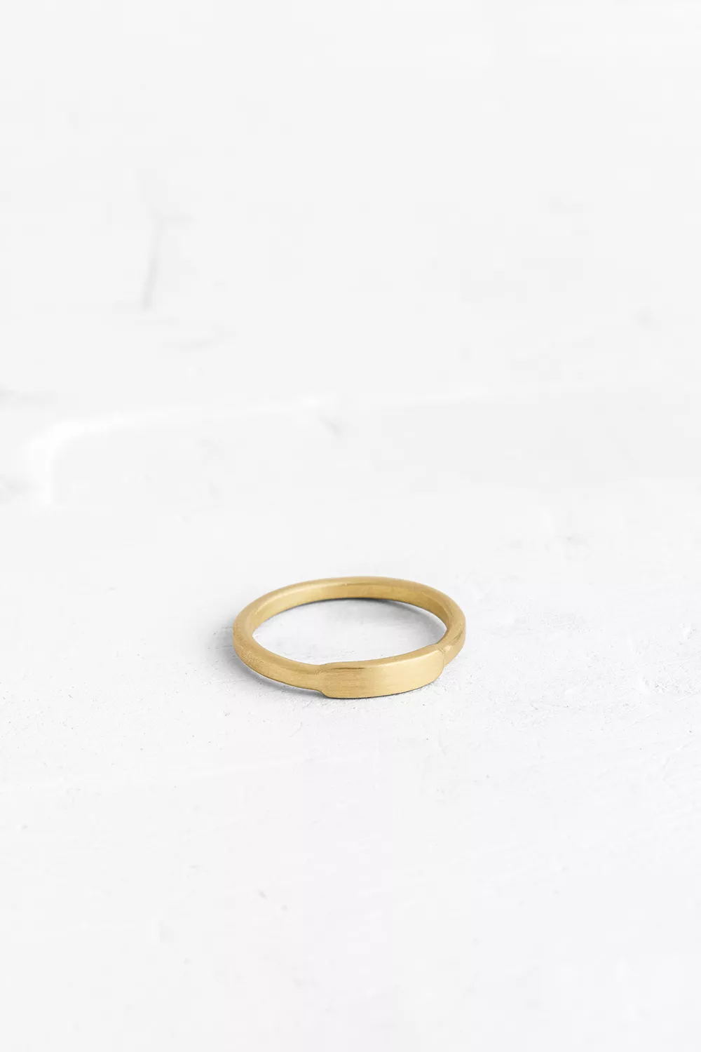 A fine ring that adorns the finger with an elegant, thin, gold band.