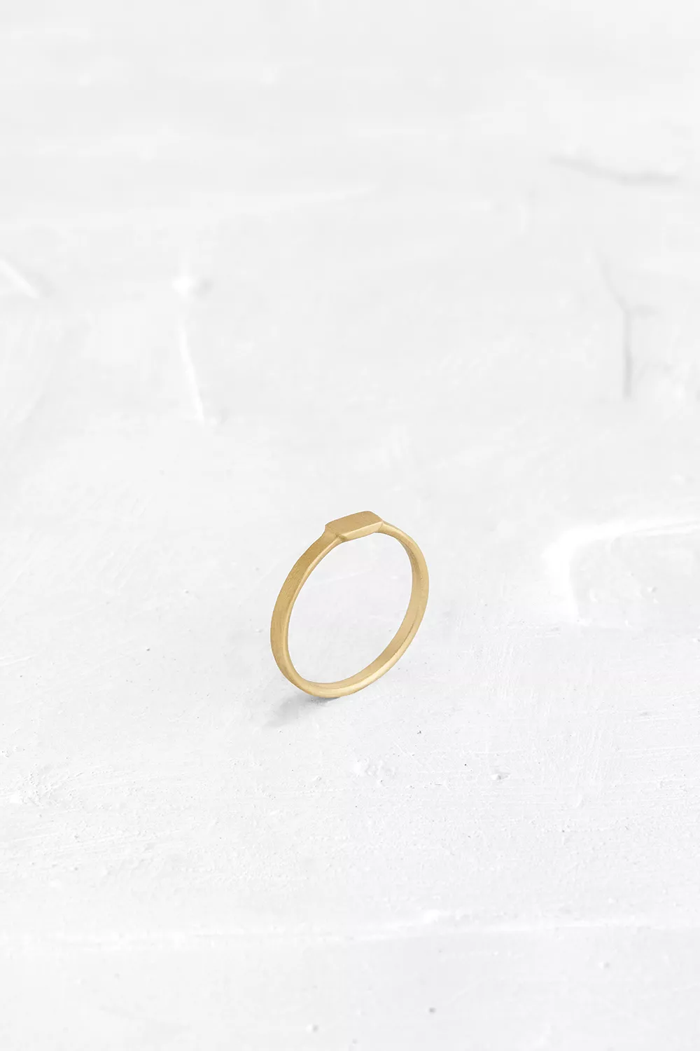 A fine ring that adorns the finger with an elegant, thin, gold band.