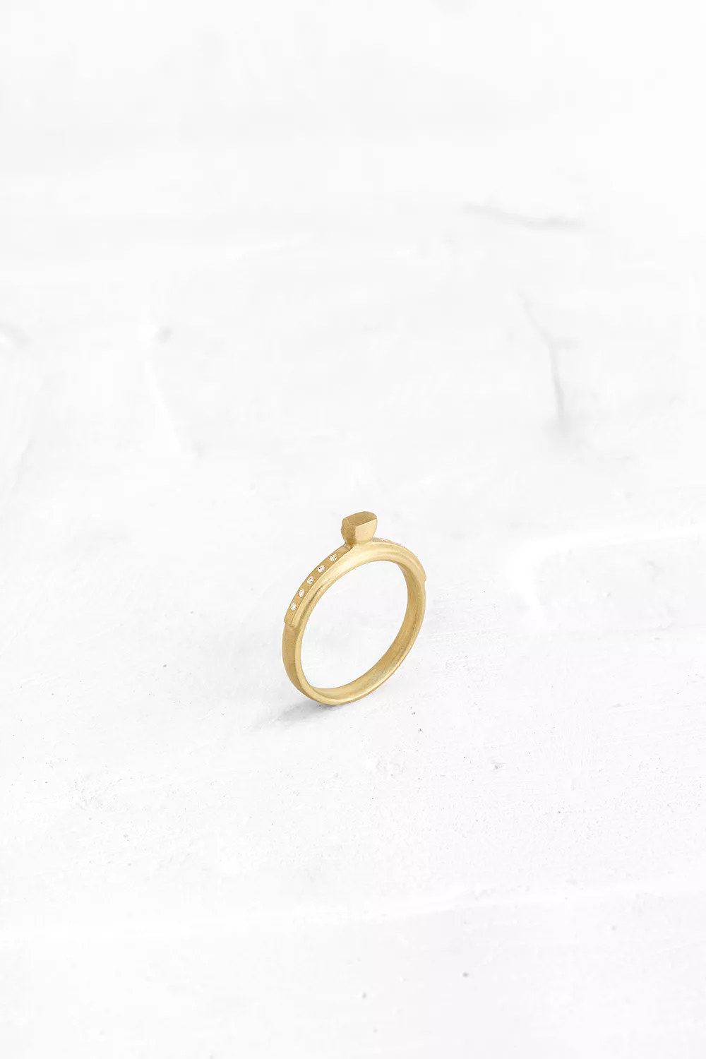 A ring designed from layers of gold - ring on ring. The top layer is speckled with diamonds, like...