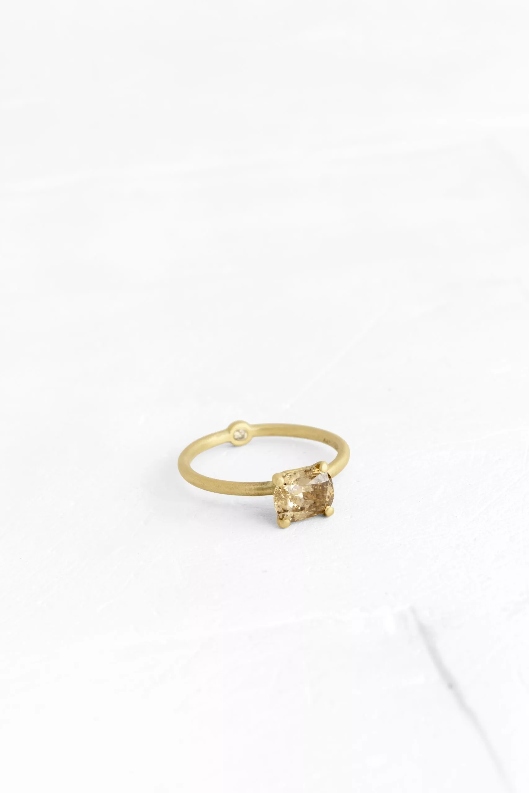 A thin, hoop ring with a setting for  a diamond. The gem shines in its full glory, exposed from ...