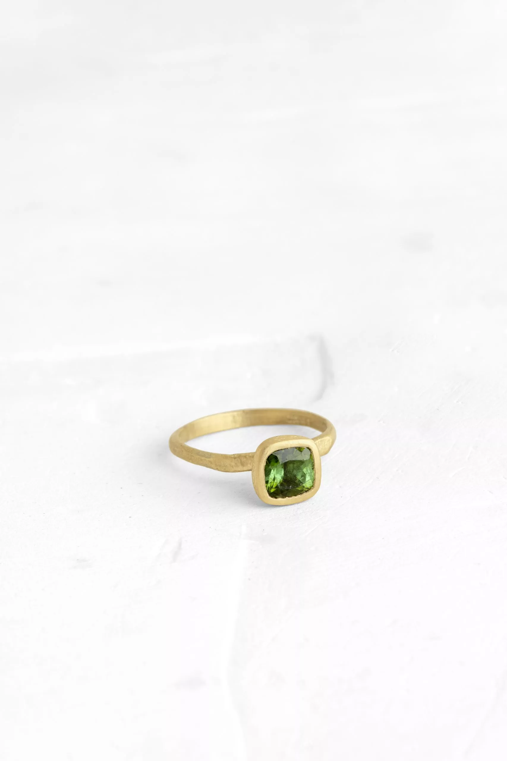 This green tourmaline is the beating-heart of this delicate ring. The raw nature of the gold band...