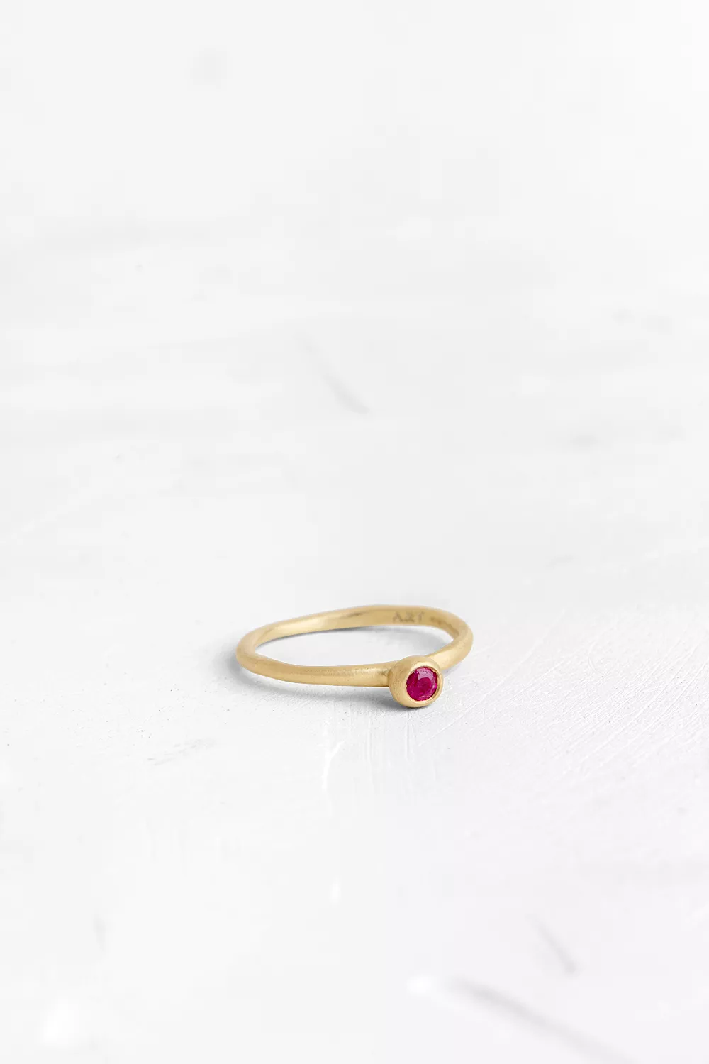 A handmade element in the shape of a hollow ball is set on top of the band, in which a small Ruby...