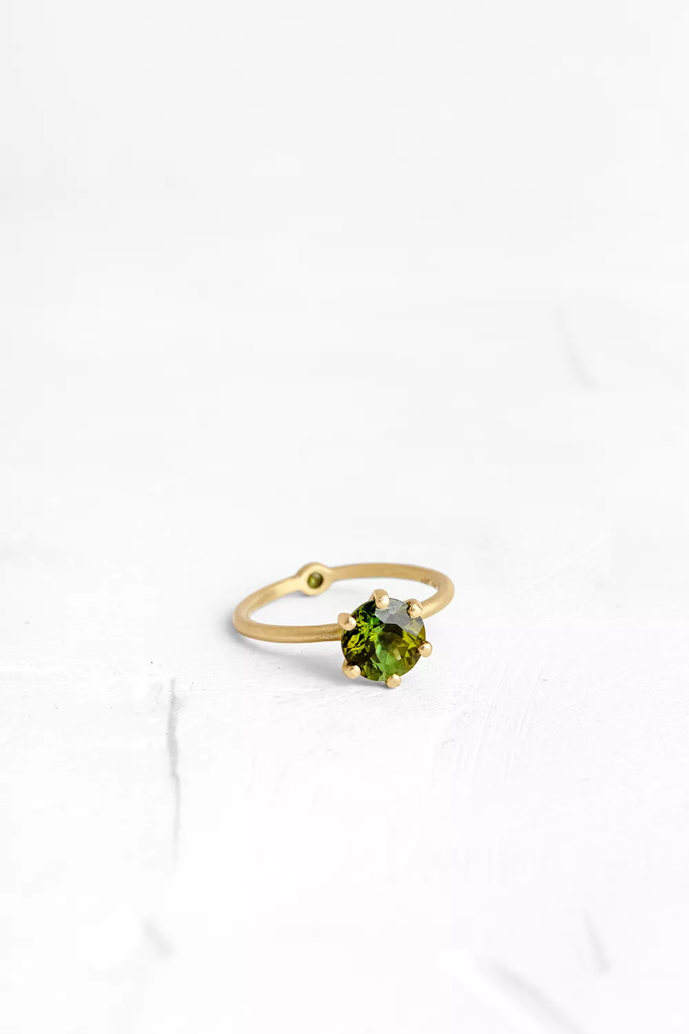 A thin, hoop ring with a setting for a stone or a diamond. The gem shines in its full glory, expo...
