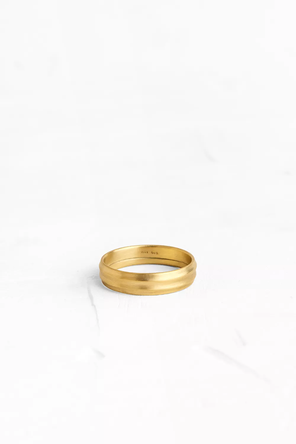 This gold band has a subtle stripes texture and sits light on the hand.