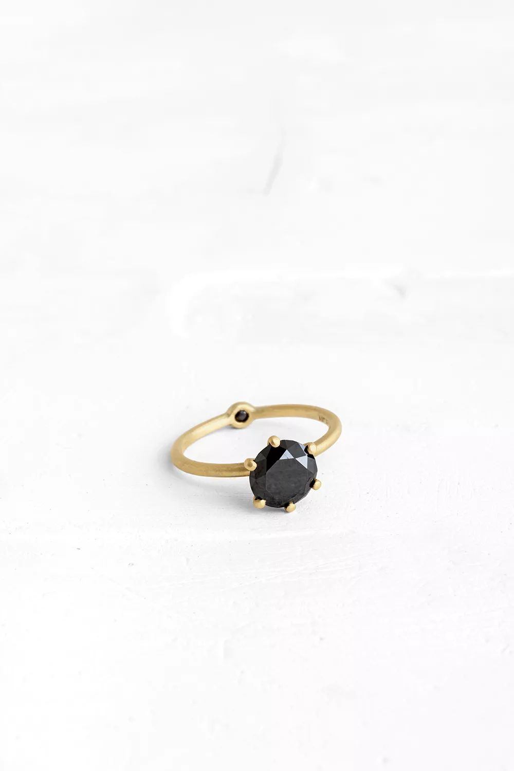 A thin, hoop ring with a setting for a stone or a diamond. The gem shines in its full glory, expo...