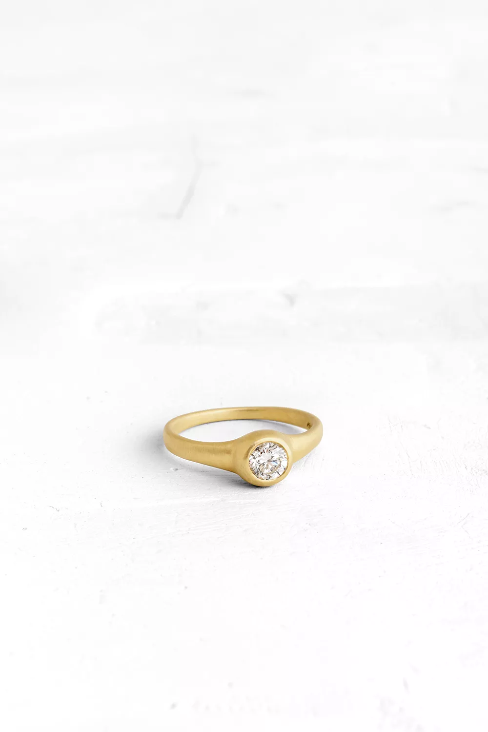 Solitaire diamond ring - the band and the bezel are both crafted into one fluid piece with a stun...