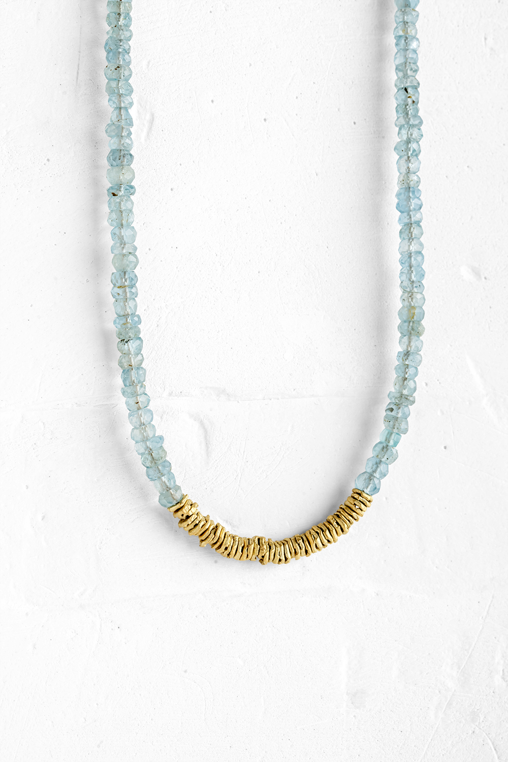 Delicate Aqua Marine gemstones are combined with rugged, folded gold links and a handcrafted gol...