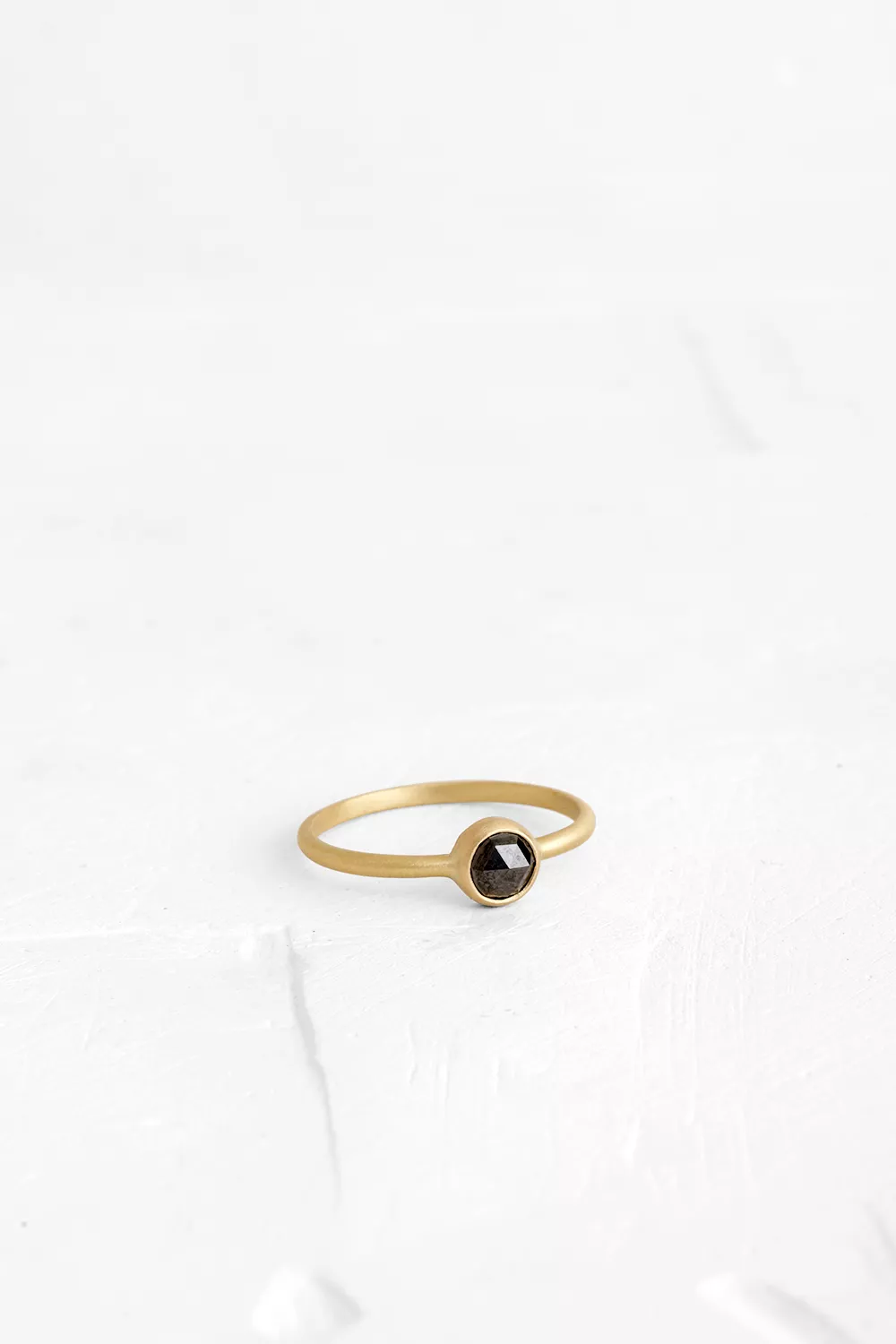 This delicate ring Set with a round Black Diamond which is the beating heart of this jewelry