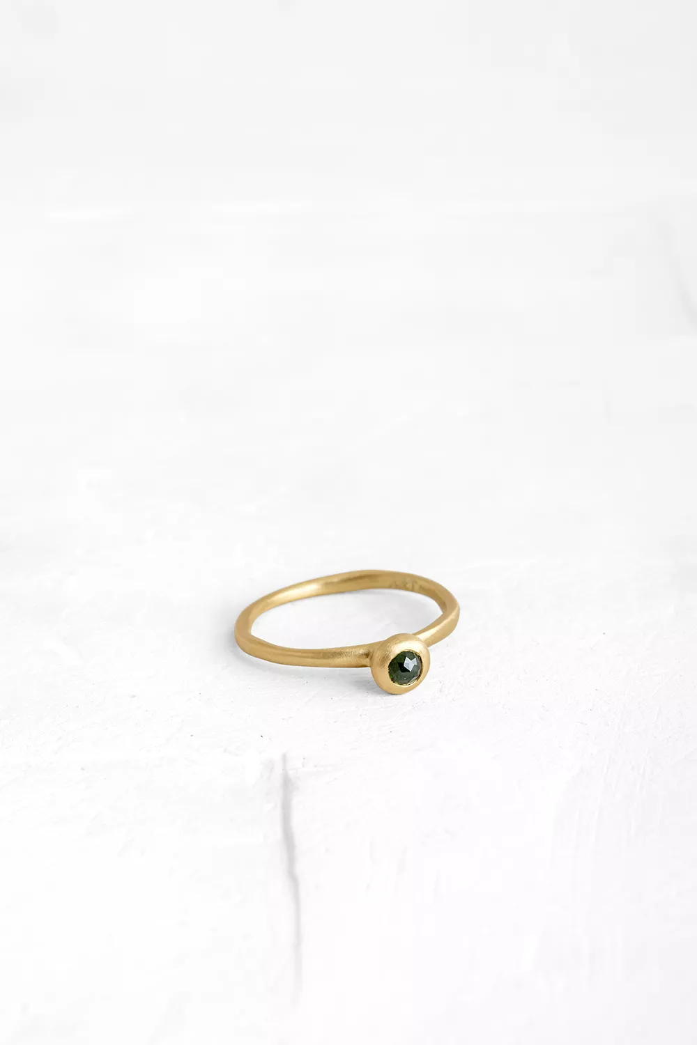 A handmade element in the shape of a hollow ball is set on top of the band, in which a small Diam...