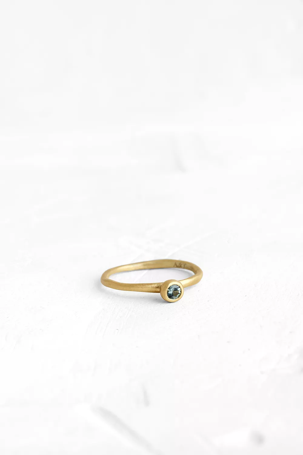 A handmade element in the shape of a hollow ball is set on top of the band, in which a small Gree...