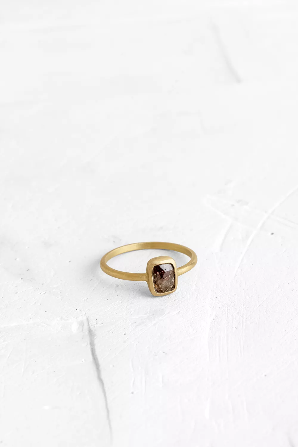 A one-of-a-kind thin ring, set with sliced stones. The setting band cases the selected stone, dif...