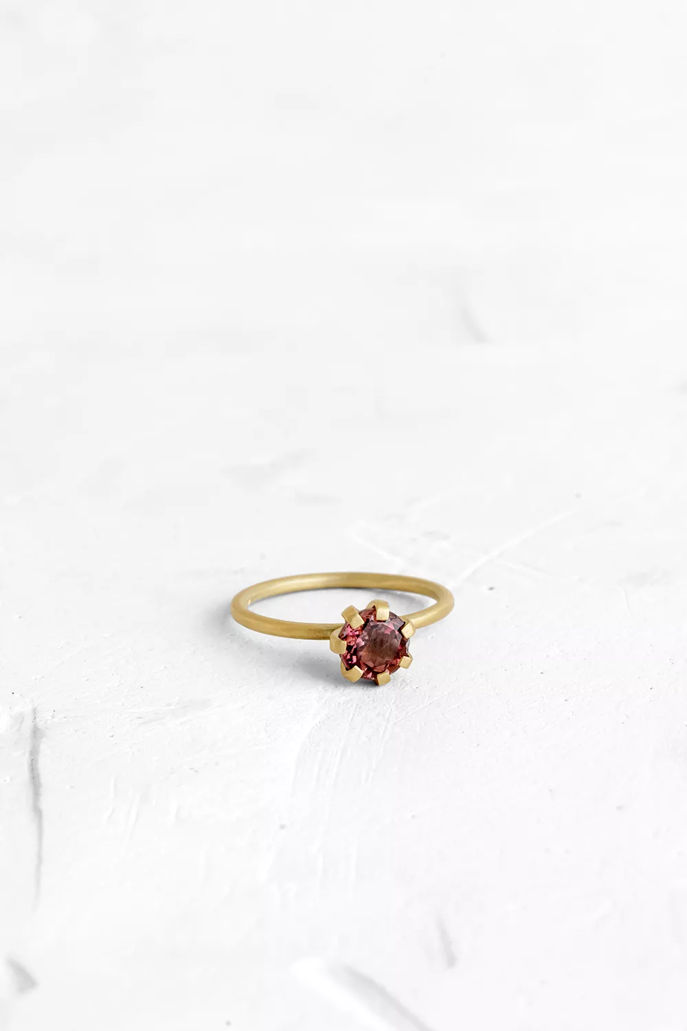 A thin, hoop ring with a setting for a stone or a diamond. The gem shines in its full glory, expo...