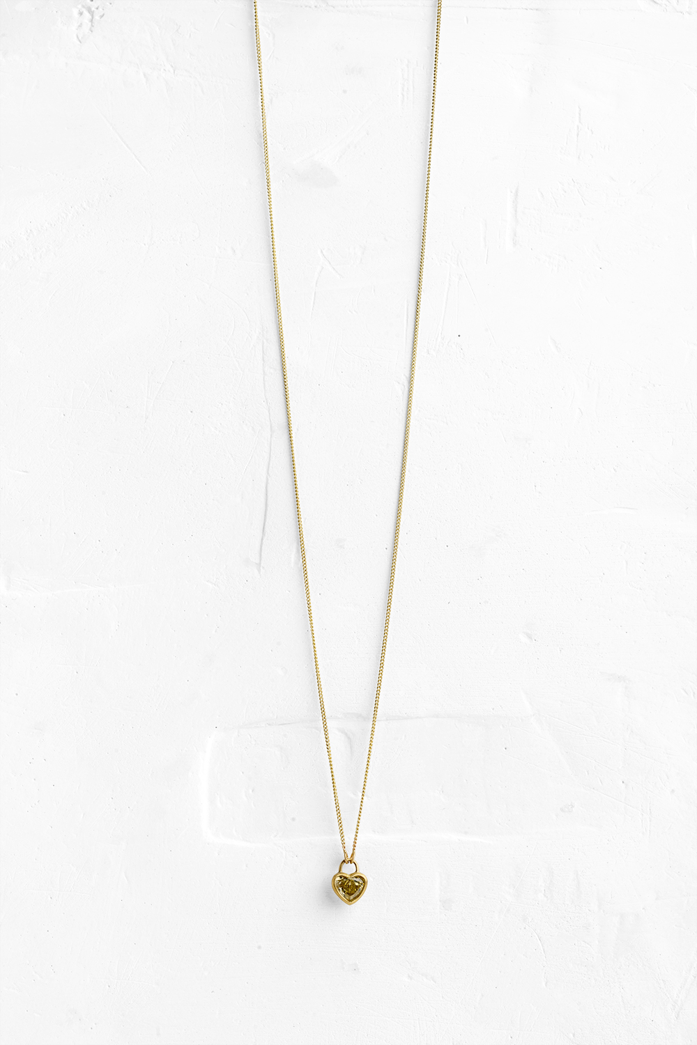 A handmade pendant is set with a Yellow Diamond in a heart shape which hangs on a delicate chain - View 2