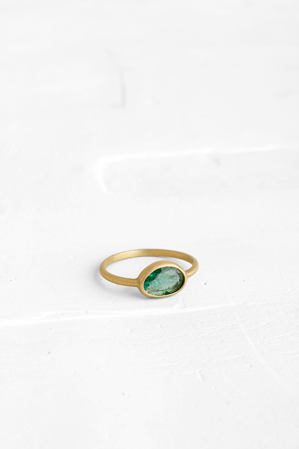 A one-of-a-kind thin ring, set with sliced stones. The setting band cases the selected stone, dif...