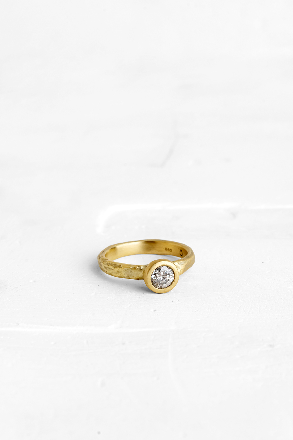 This stunning diamond is the beating-heart of this raw gold ring. The raw nature of the gold band...