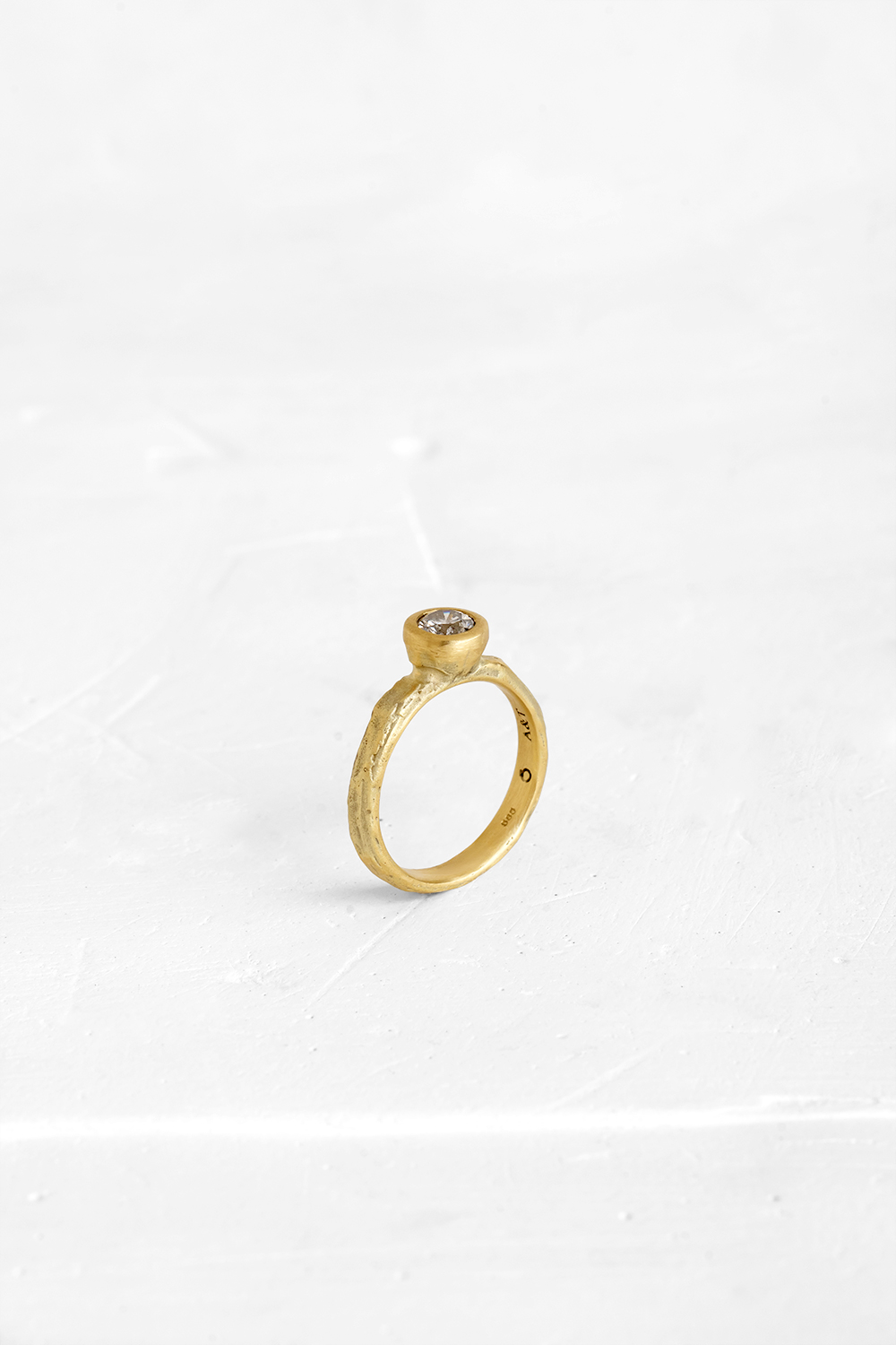 This stunning diamond is the beating-heart of this raw gold ring. The raw nature of the gold band... - View 2