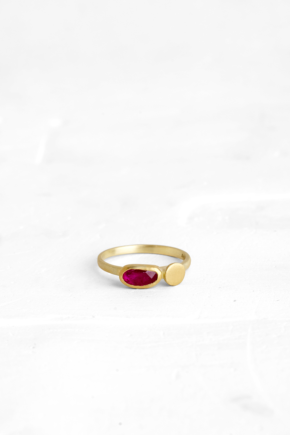 A gentle gold ring set with a slice of Ruby and a gold element coexisting side by side.Each rin...