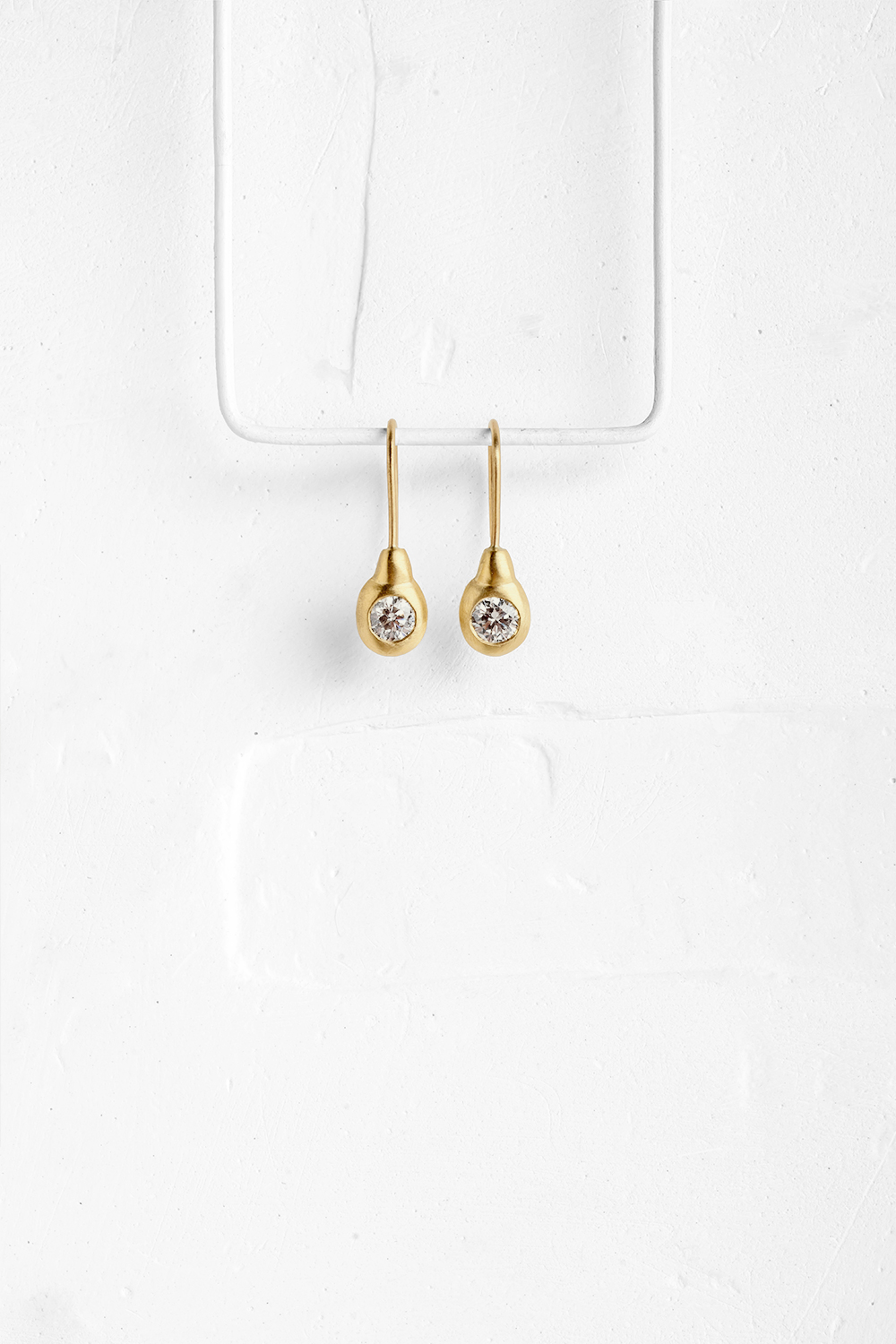 Gold earrings set with diamonds, shaped in a pear like form