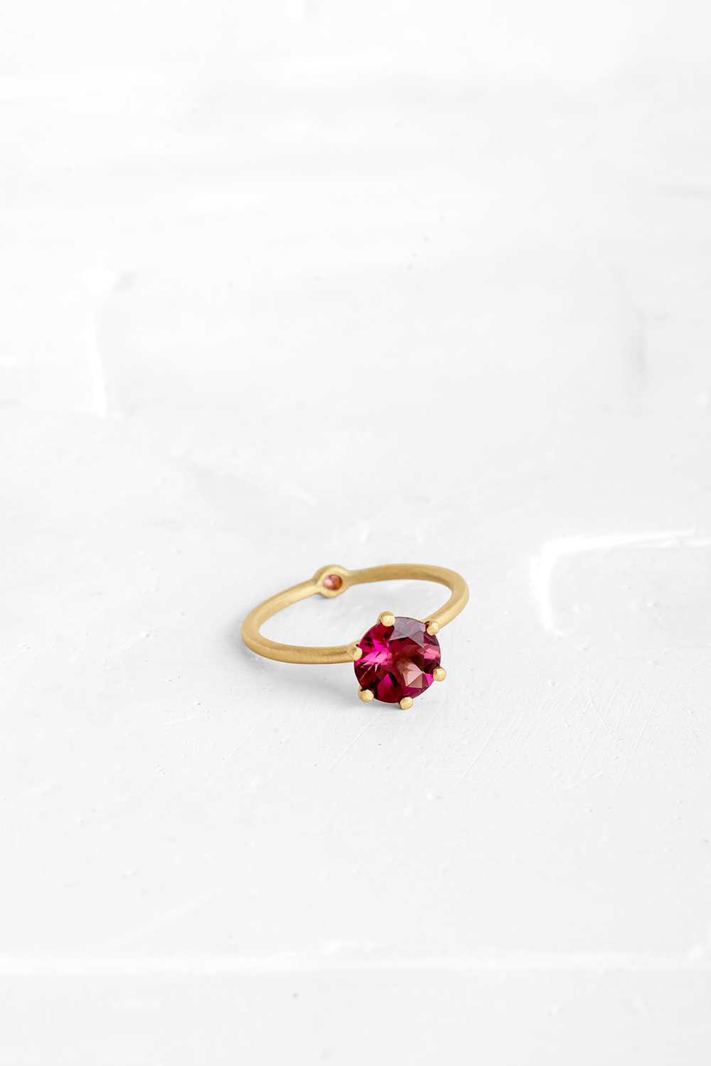 A thin, hoop ring with a setting for a stone or a diamond. The gem shines in its full glory, expo...