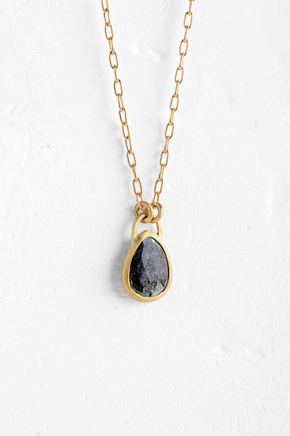 A delicate handmade pendant is embedded with a one of a kind Diamant