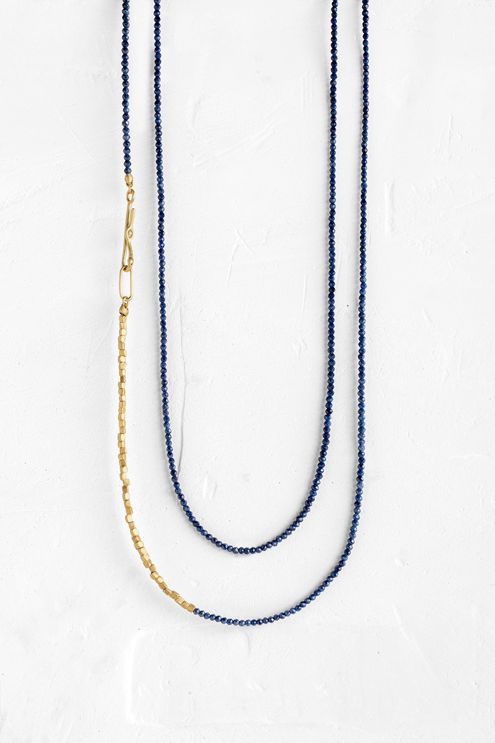A very thin chain that wraps around the neck, made of tiny Blue Saphire gems along with small gol...