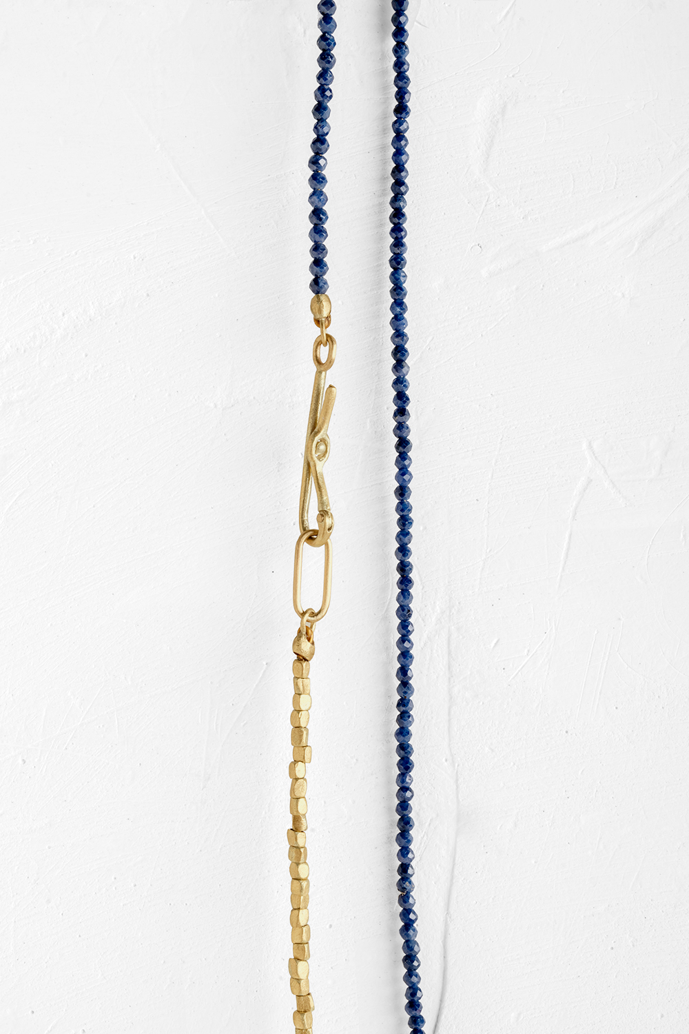 A very thin chain that wraps around the neck, made of tiny Blue Saphire gems along with small gol... - View 2
