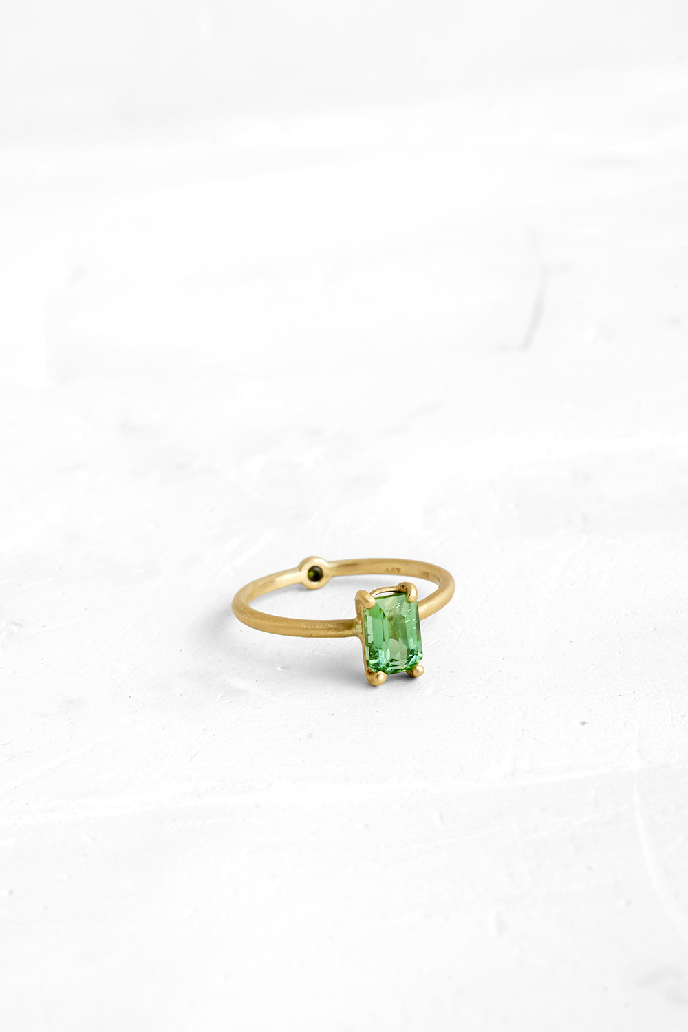 A thin, hoop ring with a setting for a stone or a diamond. The gem shines in its full glory, expo...