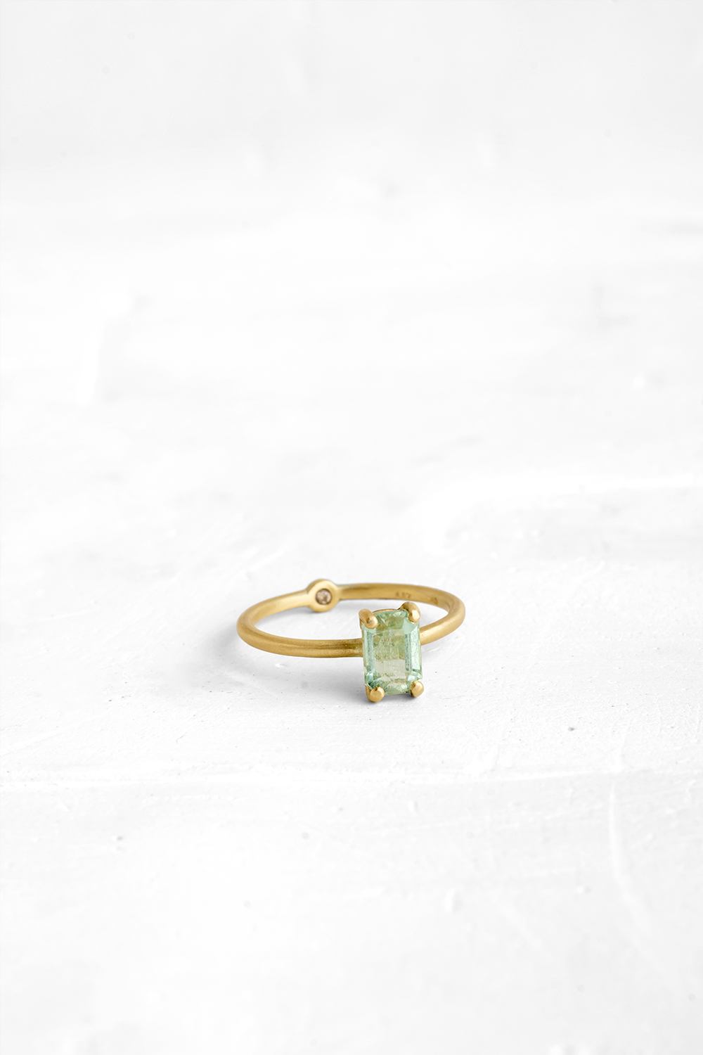 A thin, hoop ring with a setting for a stone or a diamond. The gem shines in its full glory, expo...