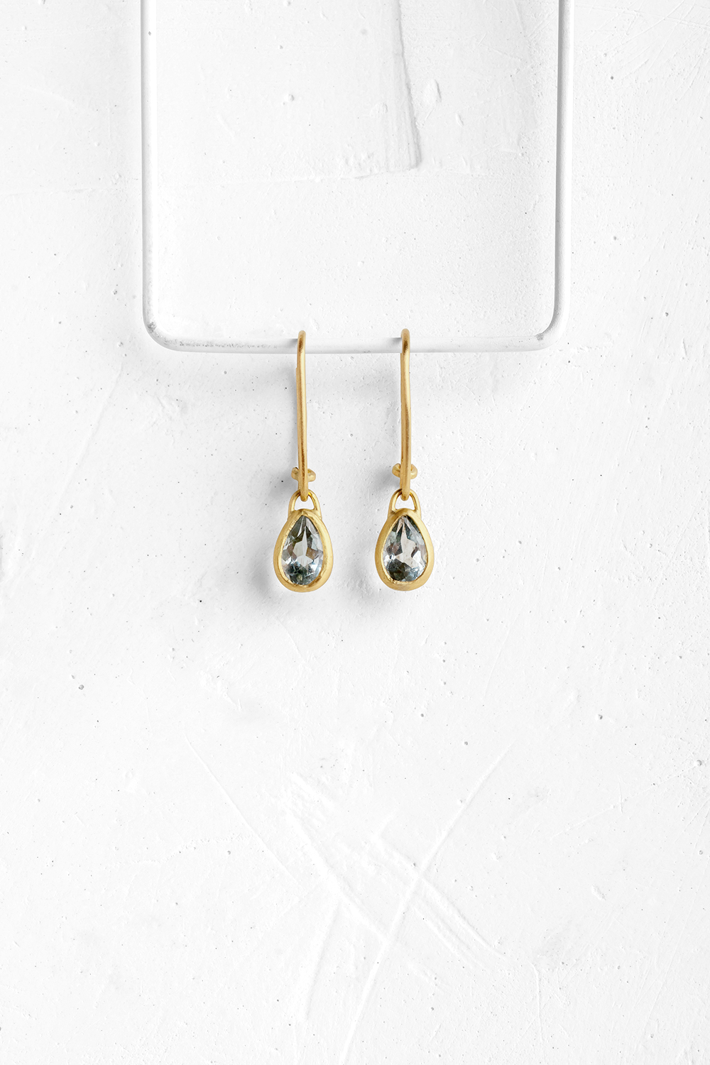 A pair of drop shaped Aqua Marine stones with a unik color, wrapped in gold hang from hand crafte...