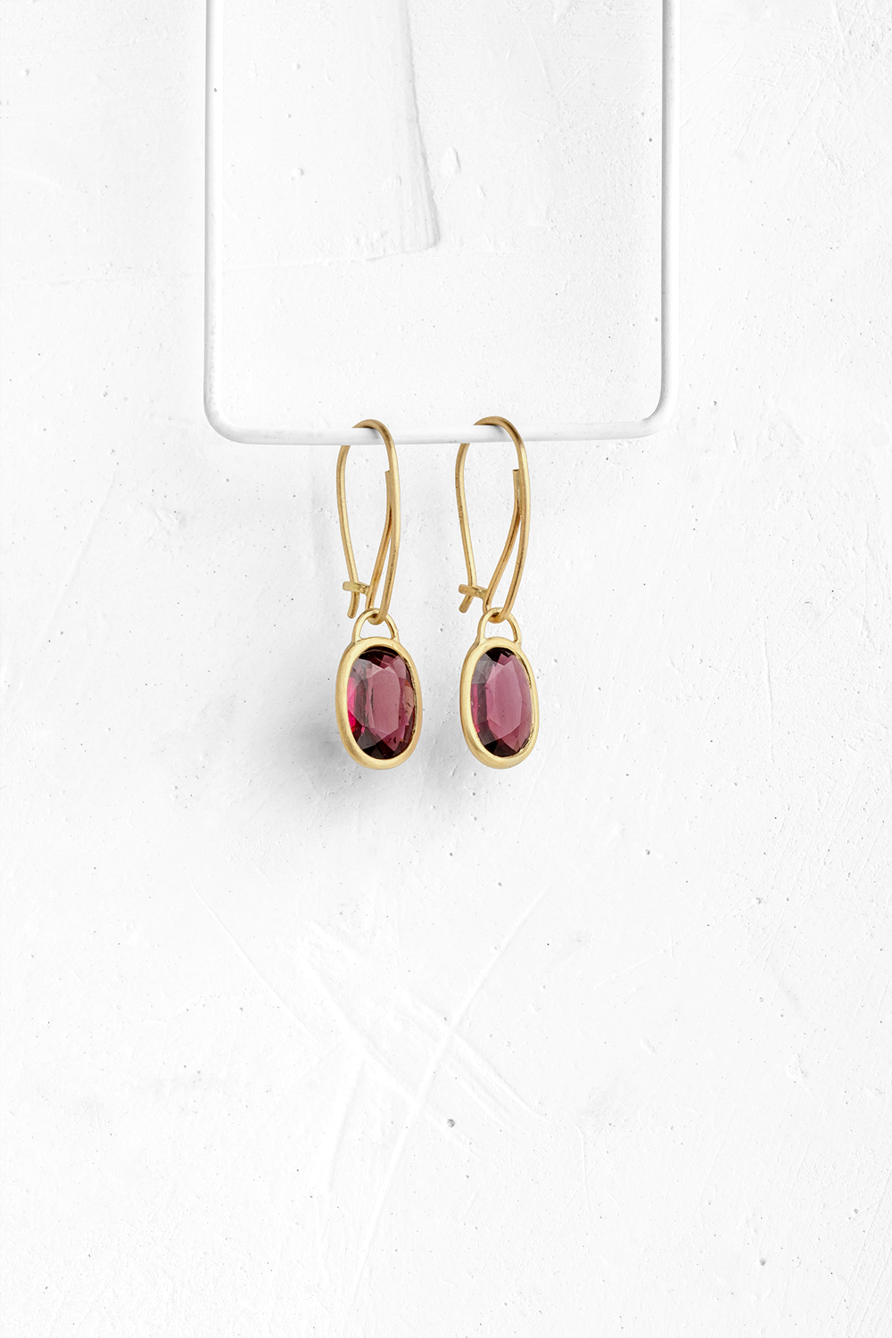 A pair of oval Rhodolite stones wrapped in gold hang from hand crafted wire hooks

&nbsp; - View 2